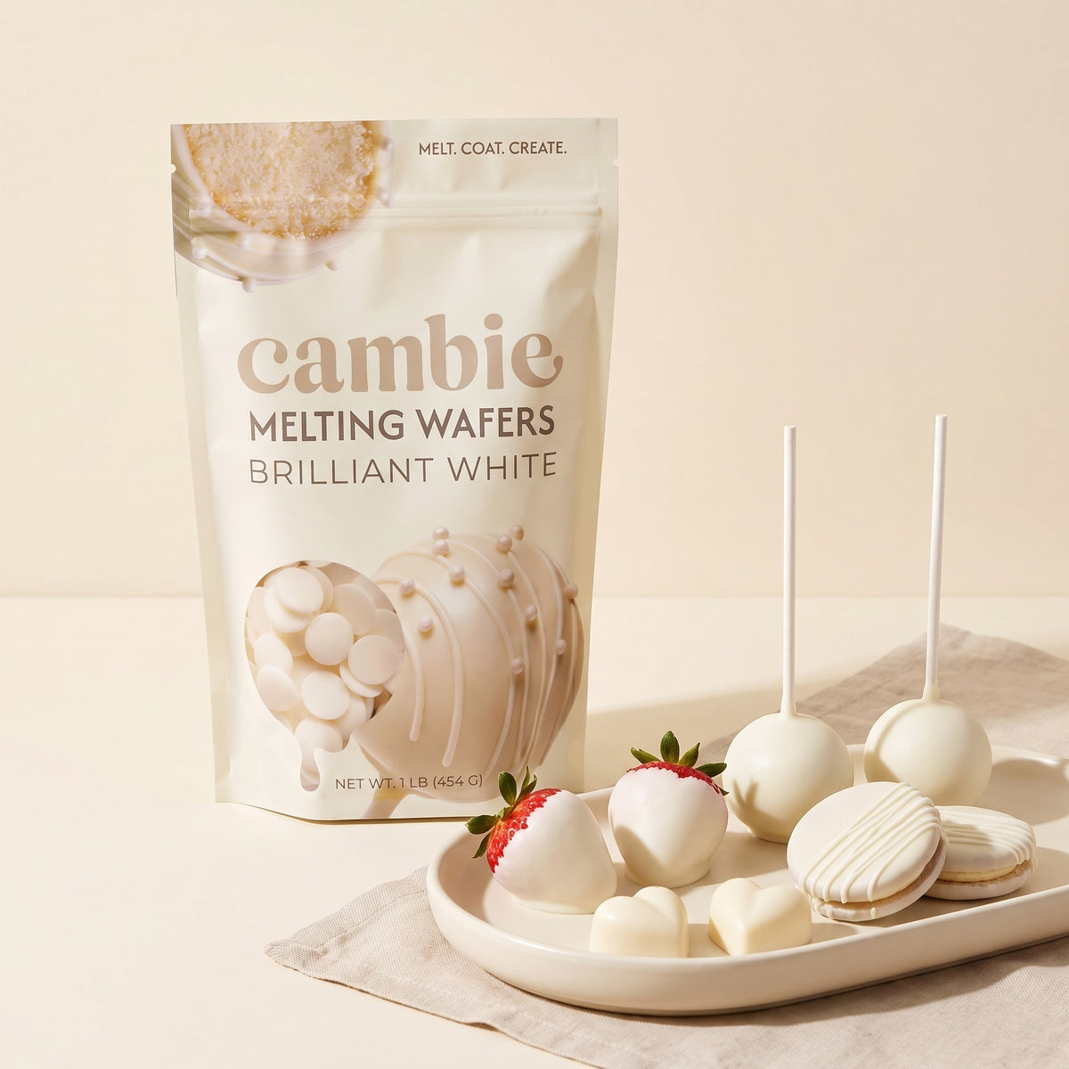 Cambie Brilliant White Melting Wafers bag with white-dipped strawberries, cake pops and cookies